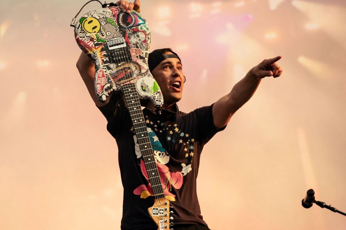 Vic Fuentes, lead singer of Pierce the Veil points out to the fans and festival goers as he holds his guitar during their Lollapalooza concert on Sunday.