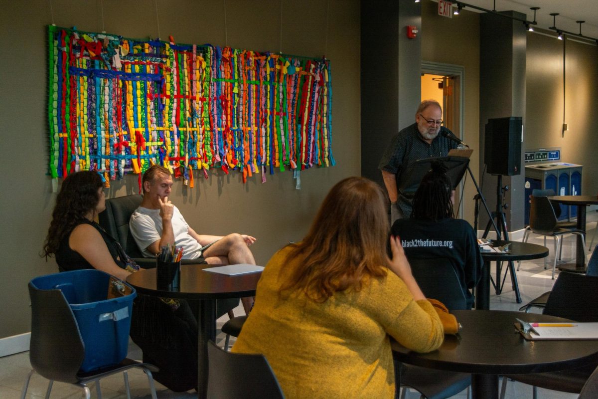 Local writer Will Reger reads poetry from one of his books during the first Song, Poetry, Expression, Art, and Knowledge (SPEAK) Cafe event at Krannert Art Museum on Thursday evening, Sept. 5. The monthly open mic aims to provide a space for anyone to create and present their work.