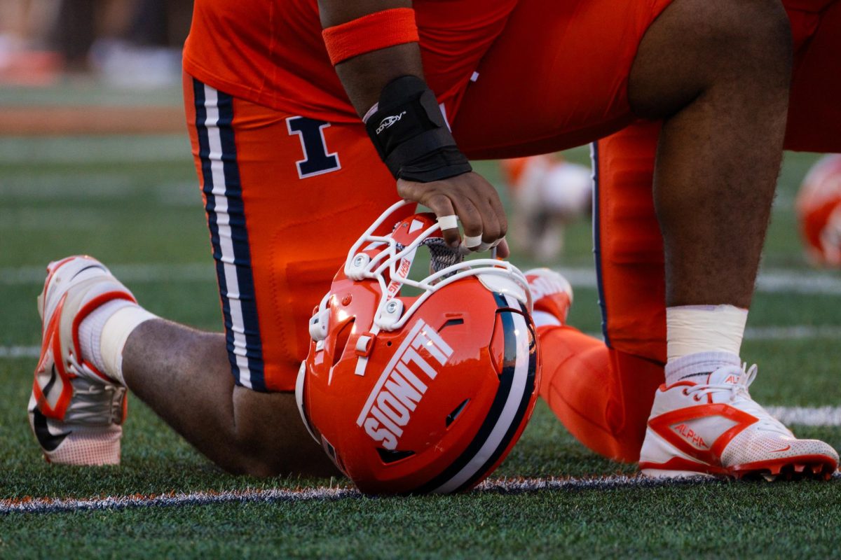 Redshirt freshman Jeremiah Warren sets his helmet down and prays before the game against Kansas on Saturday, Sept. 7.