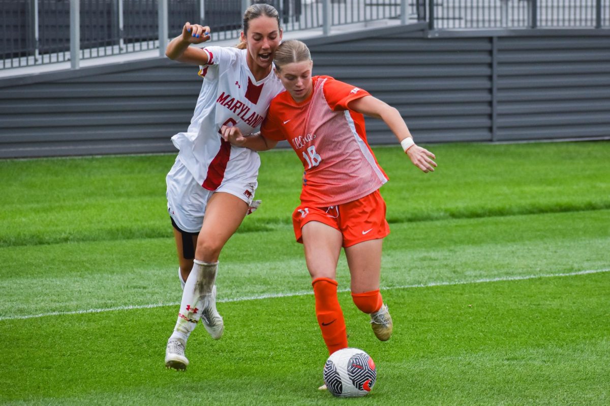 Sarah Foley dribbling the forward while fighting for posession after her teammate passed the ball to her.