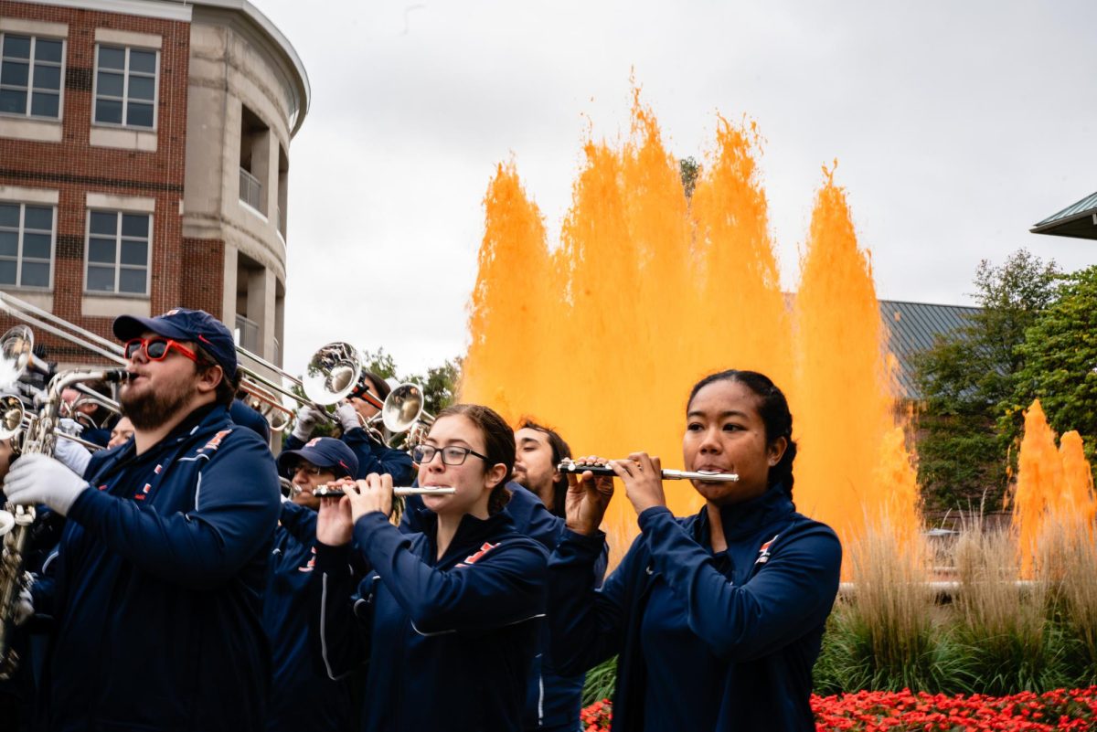 Marching Illini plays in front of the Alice Campbell Alumni Center as the fountain was dyed orange on Oct. 15, 2023.