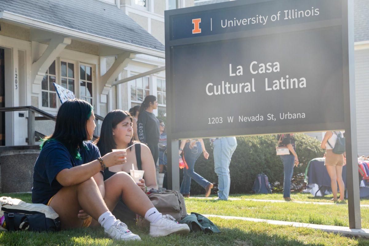 Students sit by La Casa on Nevada street in Urbana during the 2023 El Grito de Independencia celebration.