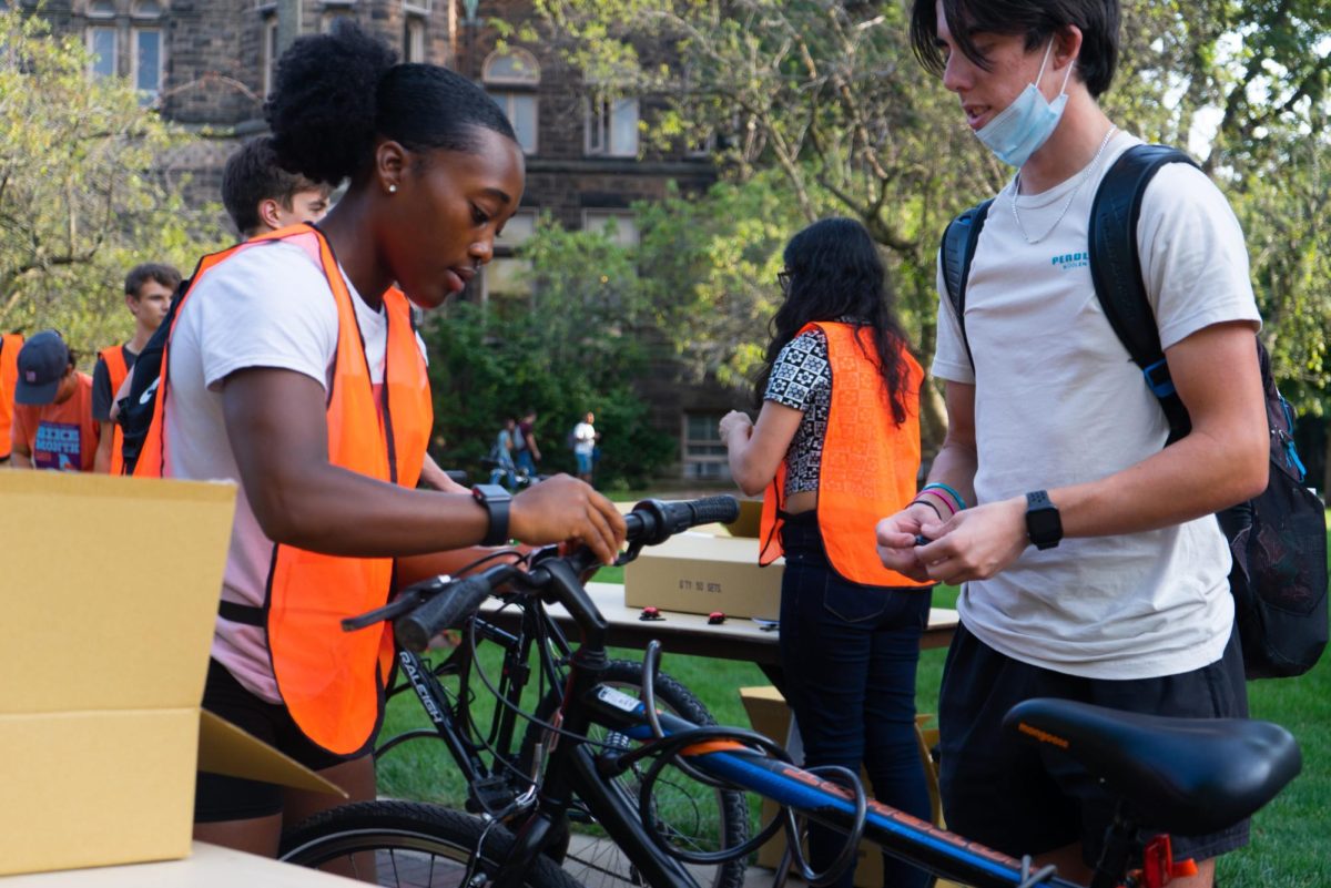 Volunteer Jada Allen (left), then junior in LAS, hands Nicholas Costello, then freshman in Engineering, a bike light during the Light the Night bike event on Sept. 15, 2022.