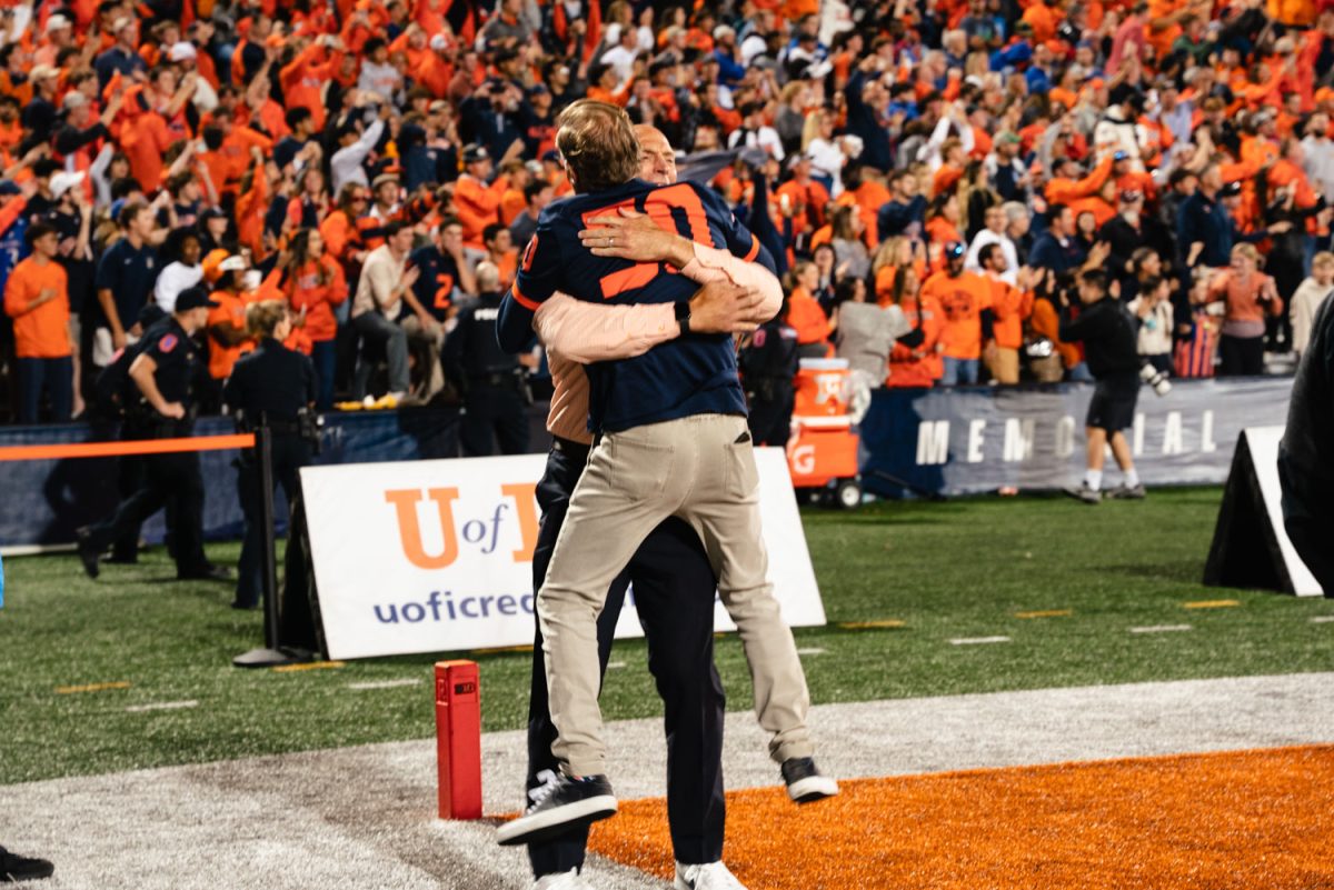Athletic director Josh Whitman lifts Larry Gies in excitement as Illinois claims victory at the end of the fourth quarter.