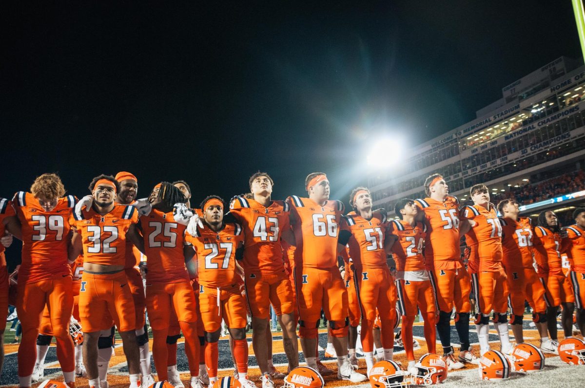 The Illinois football team lines up at the back of the endzone to listen and sing along to the Marching Illini playing “Hail to the Orange” after their big upset win agains Kansas on Sept. 7.