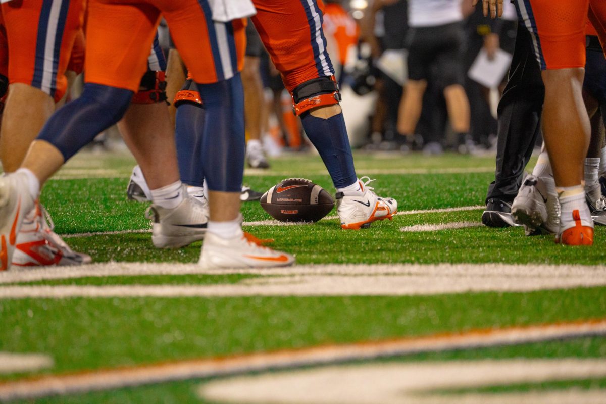 The Illinois Fighting Illini walk around a football Wide receiver Malik Elzy leaps into the air and looks to the sky for the touchdown pass during the first football game of the 2024 season in Memorial Stadium on West Kirby Ave.