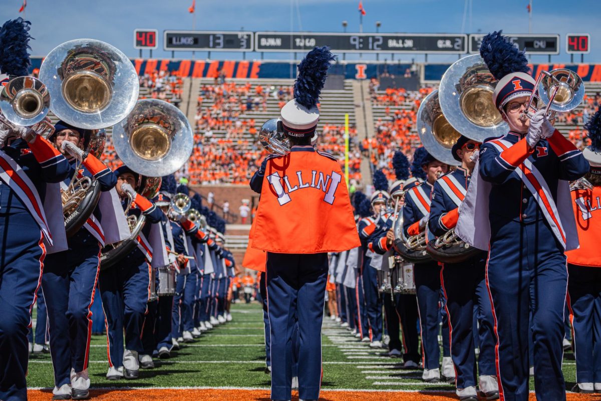 The Illinois Marching Illini march and play in formation during the Illinois v Central Michigan homecoming halftime show.