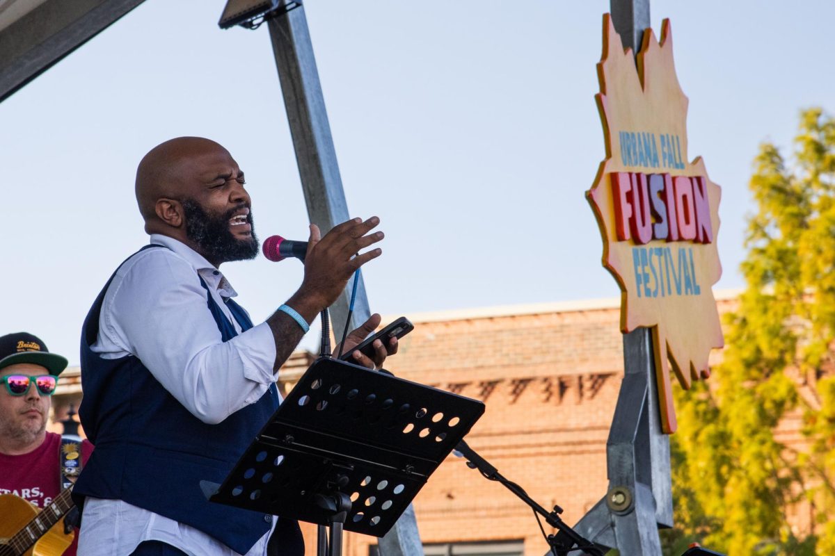 Champaign County Deputy Treasurer DeShawn Williams sings alongside New Souls, an R&B, soul, and hip-hop band, on stage at 40 North's Fall Fusion Festival in Downtown Urbana on Saturday. Williams is currently running for mayor of the city of Urbana as a Democrat, and will run against Annie Feldmeier Adams in the February primary.