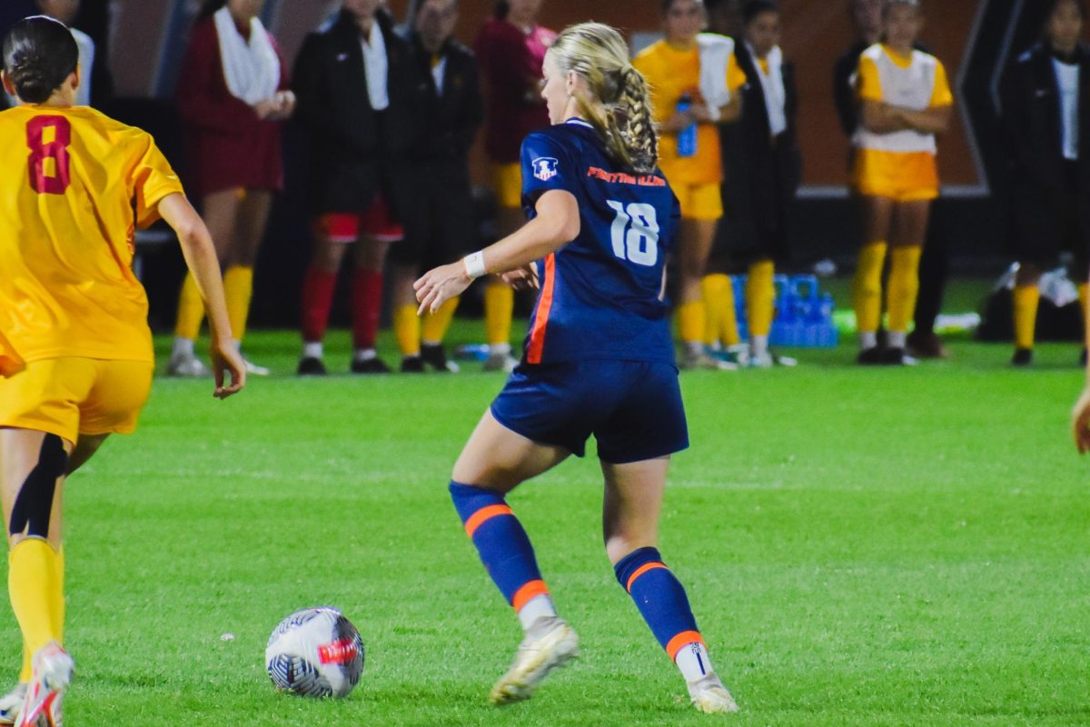 Sarah Foley dribbles the ball while avoiding opponents during a soccer match against USC on Oct. 10 in Champaign.