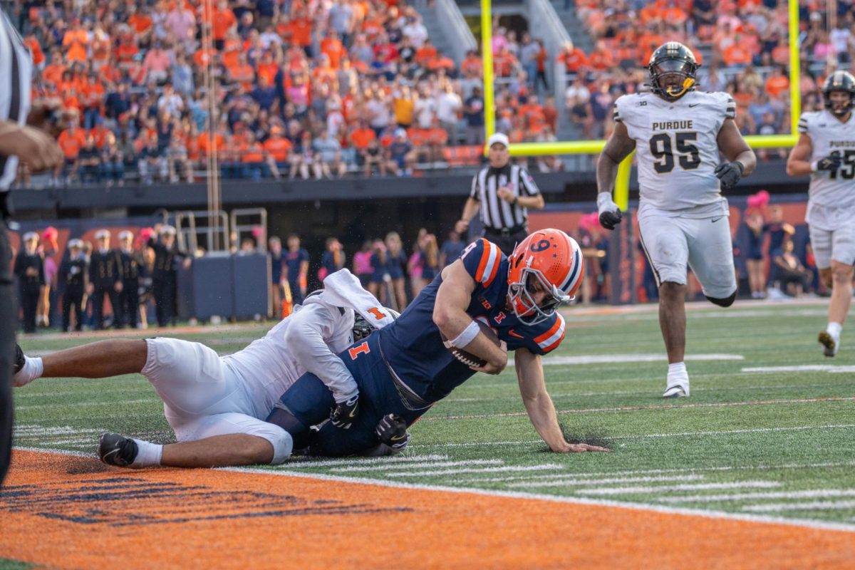 Quarterback Luke Altmyer rushes with the ball but gets taken down during the Illinois v Purdue football game on Oct. 12 in Memorial Stadium.