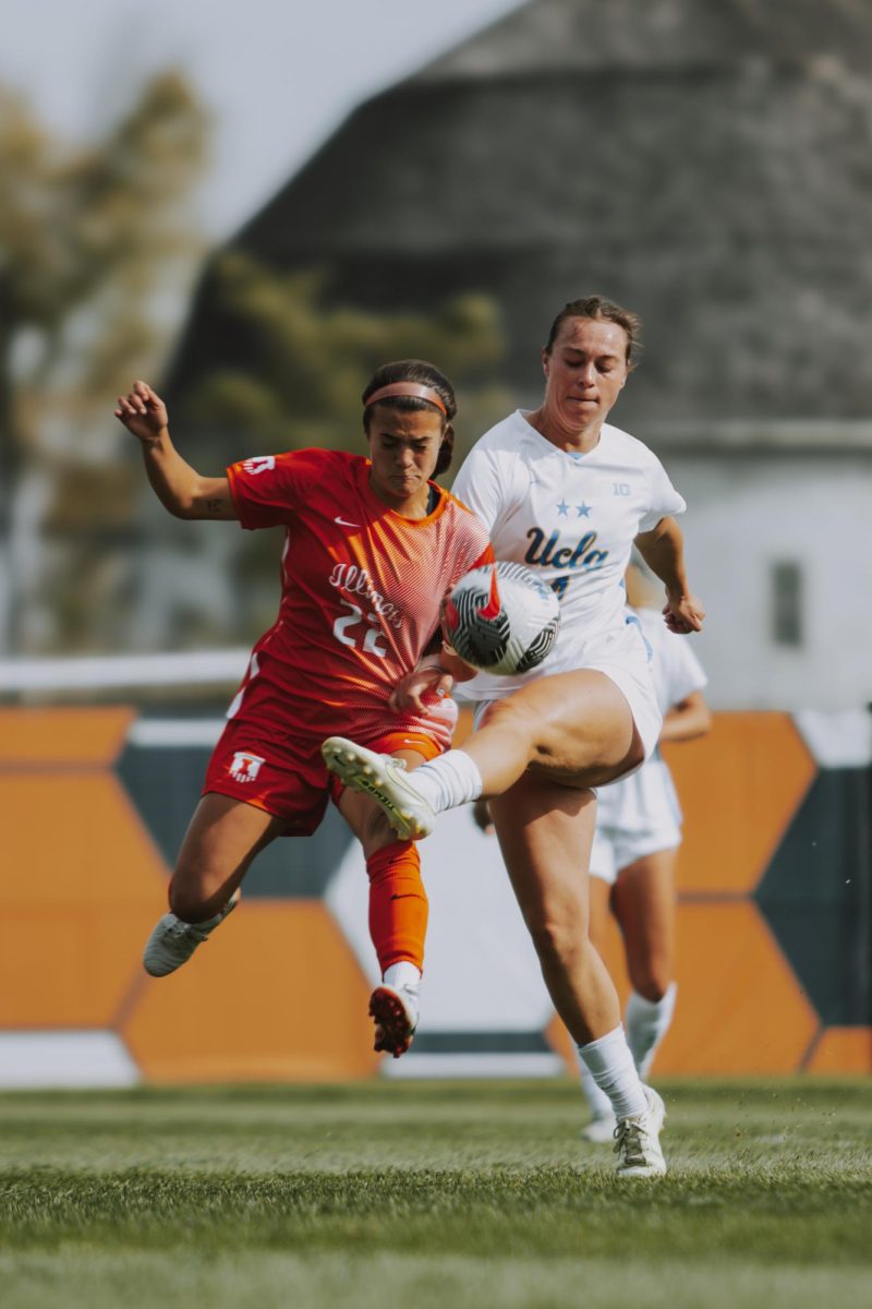 Junior midfielder and defender Lia Howard  battles fiercely for possession of the ball against her UCLA opponent, determined to maintain control.