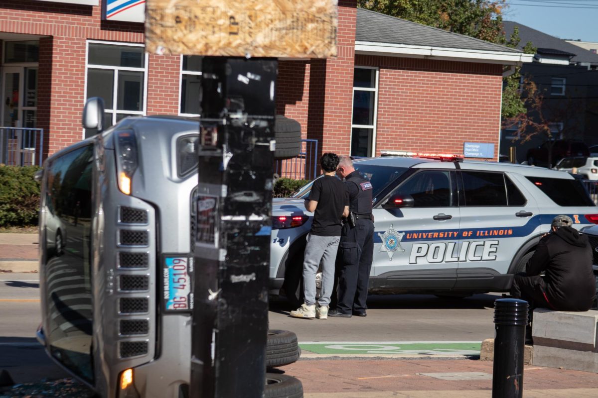 At the intersection of Third and Green on Sunday, a police officer assists a person involved in the crash.