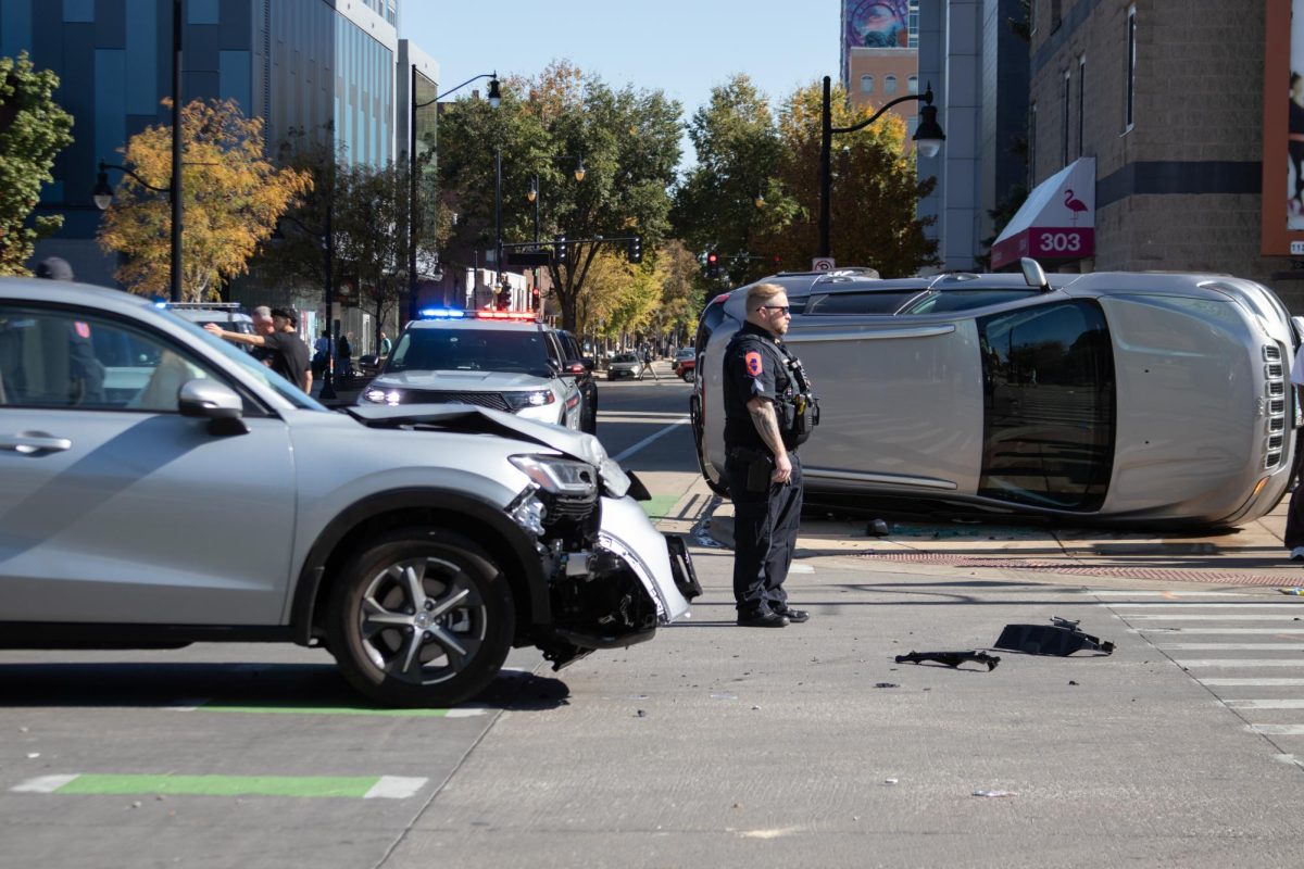 Police officer on scene of a car accident at the intersection of Third and Green streets on Sunday, involving an overturned vehicle and another damaged SUV.