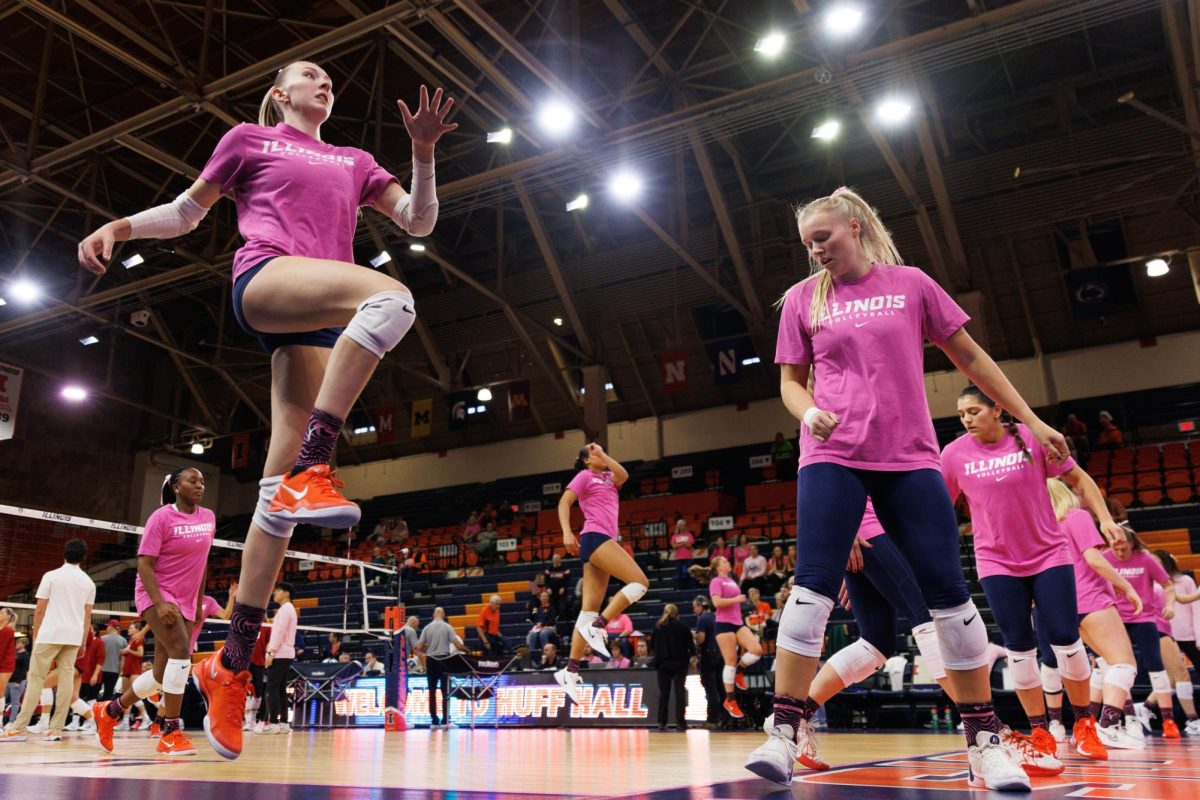 The Fighting Illini Volleyball team is performing high jumps as they warm up before their match up against the Indiana Hoosiers at Huff Hall Oct. 16.