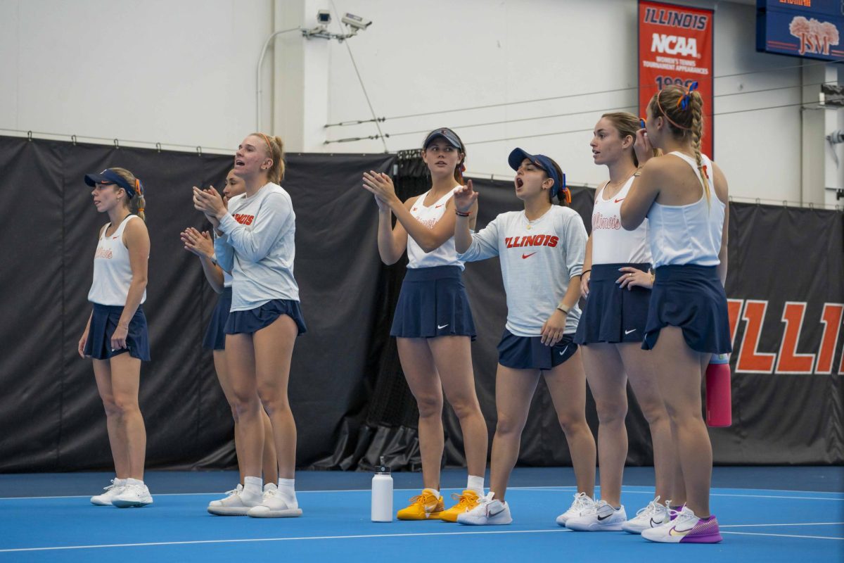 The Illini cheer on their teammates on April 12 at the Atkins Tennis Center.