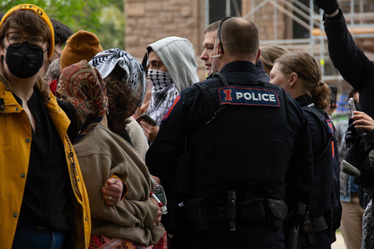 UIPD officers approach protestors at the Palestinian encampment at the foot of Alma Mater on Apr. 26.