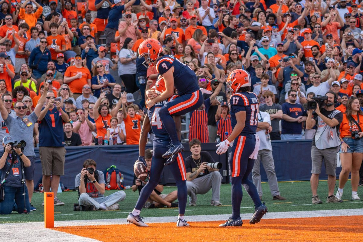 Junior quarterback Luke Altmyer jumps onto senior wide receiver Zakhari Franklin following a score against Purdue on Oct. 12.