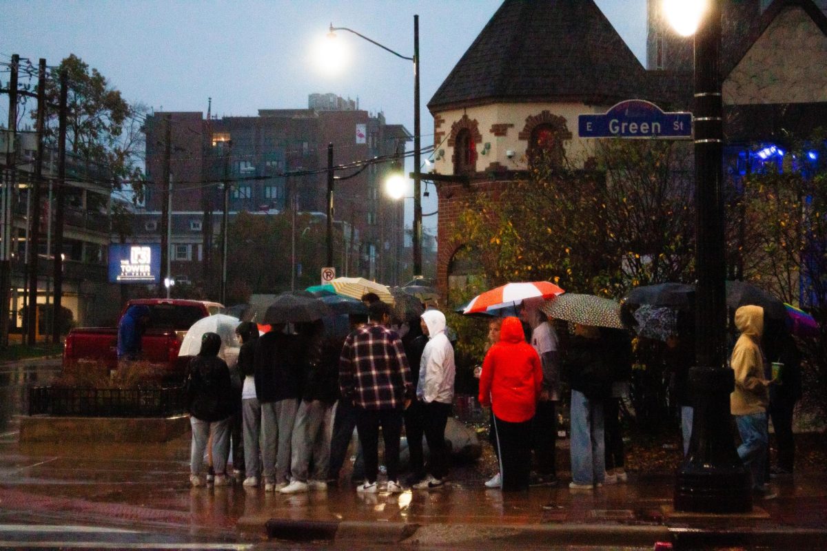 Students bear a strong downpour while waiting in line for The Red Lion's Election Day Block on Tuesday shortly after 6 am.