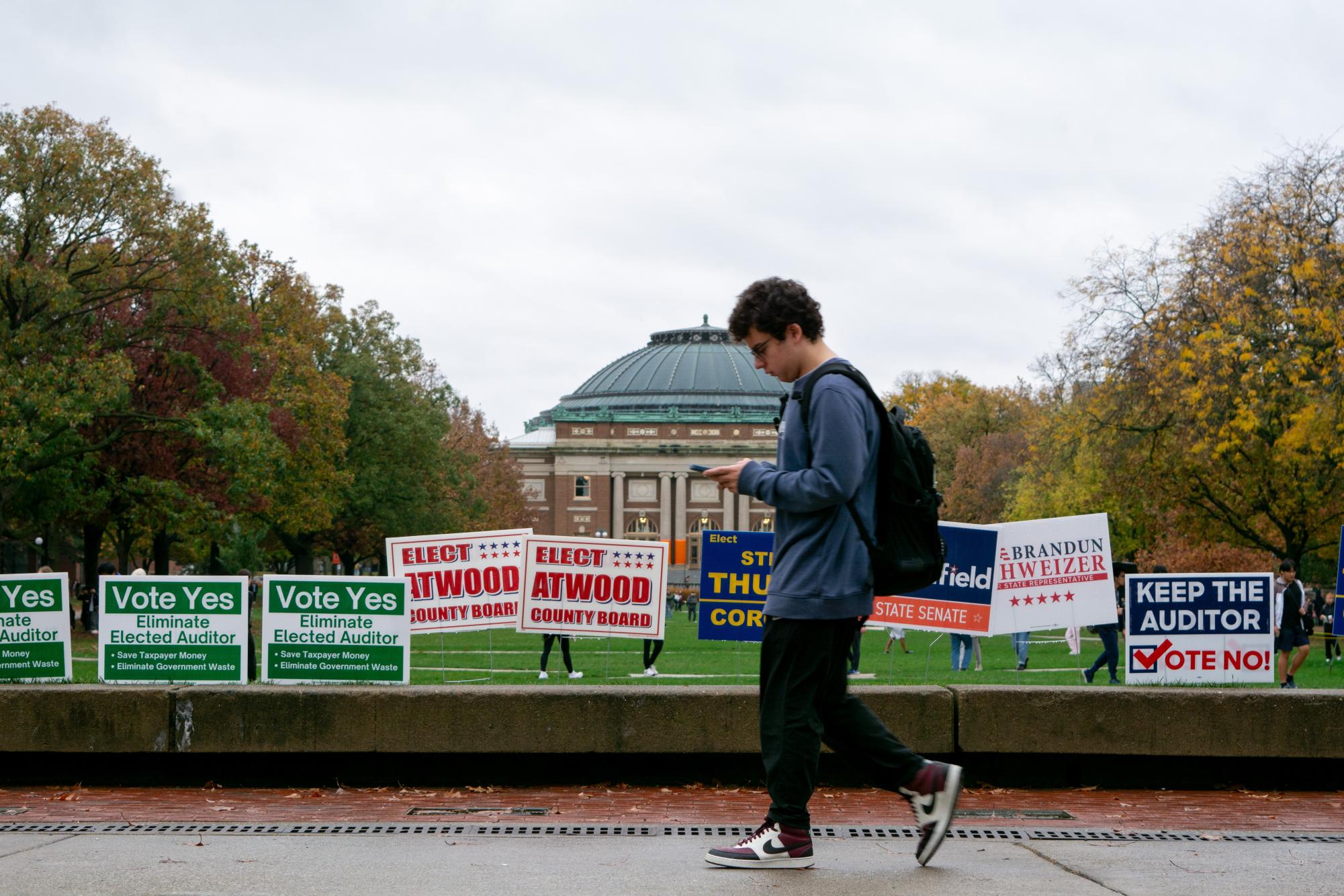 A student walks by the Illini Union on Election Day. At 11 a.m., the voting line ran through hallways and snaked through the Union ballroom.