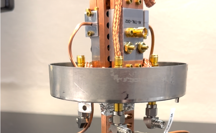 The two metal enclosures on the upper half of the picture contain superconducting qubits.