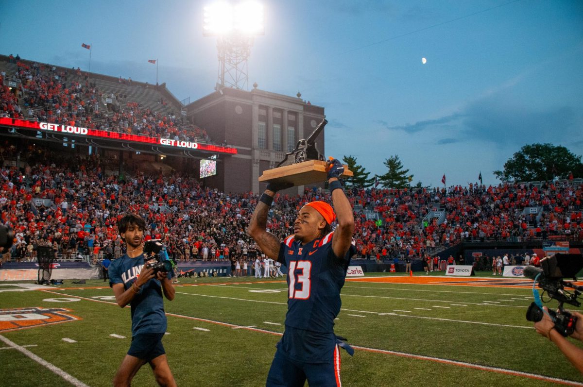 Senior wide receiver Pat Bryant holds up the Cannon Trophy after Illinois' victory at home over Purdue on Oct. 12.