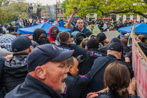 Police attempt to breach a circle of protesters to remove tents during the encampment protest next to Alma Mater on April 26, 2024.