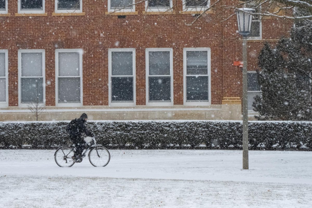 A biker rides by the Main Quad under heavy snowfall on Jan. 5.
