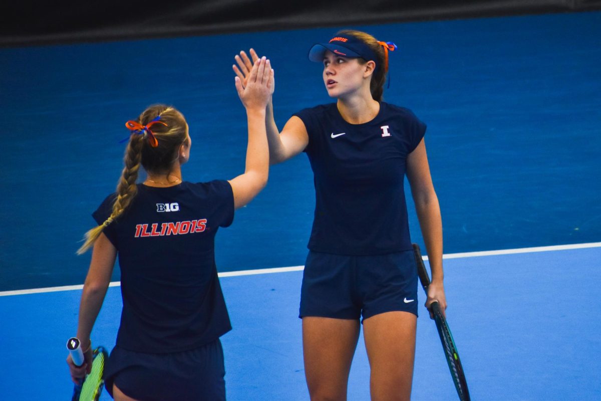 Senior Kasia Treiber (left) and junior McKenna Shaefbauer (right) high five during a doubles match against Northwestern. The Illini defeated the Wildcats 4-2 on Jan. 25.