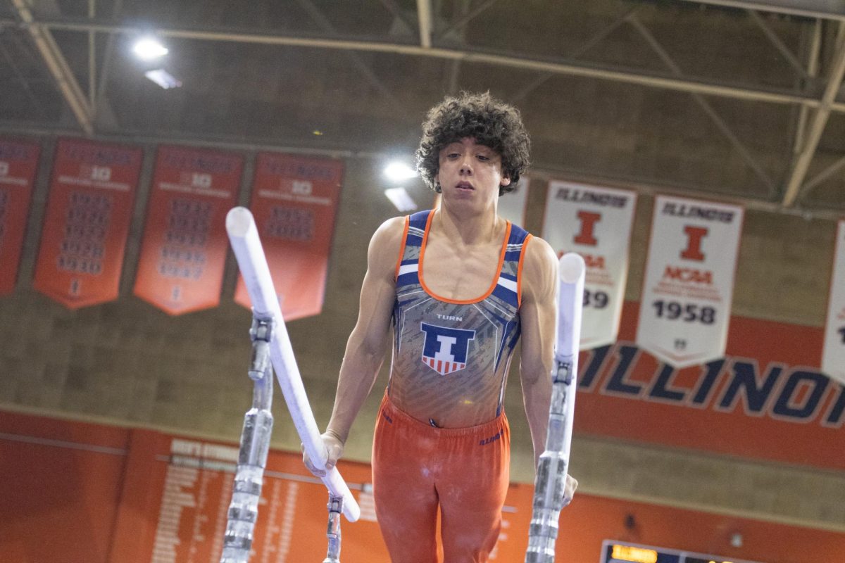 Freshman Ian Sandoval holds himself up on the parallel bars during a meet against Nebraska on Jan. 31.
