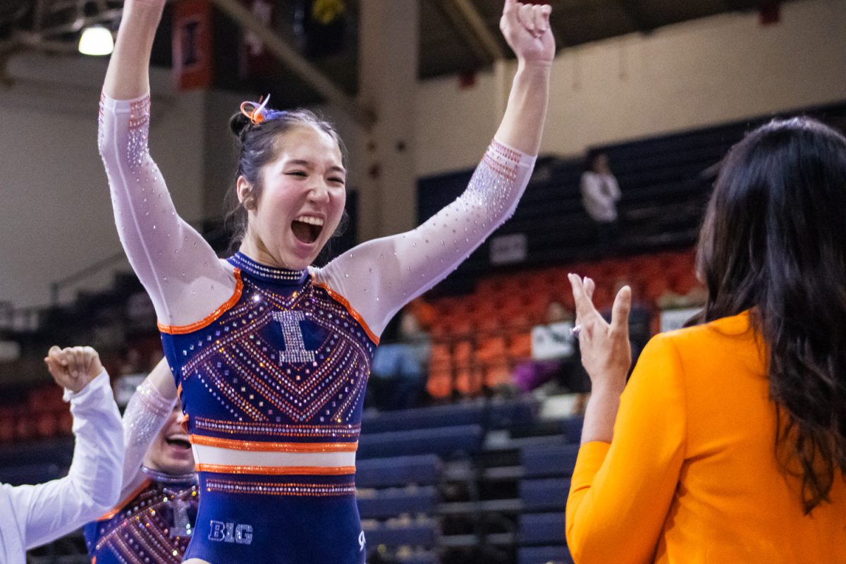 Freshman Chloe Cho celebrates with head coach Nadalie Walsh after her beam routine during a meet against Missouri on Feb. 9. Illinois lost the second meet of Alumni Weekend 197.200-196.675.