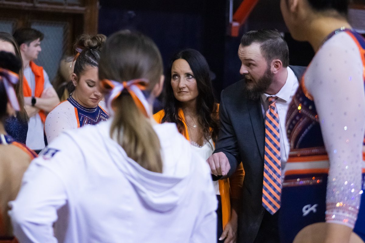 Associate head coach Josh Nilson talks to the women’s gymnastics team after the second rotation of a meet against Missouri on Feb. 9.