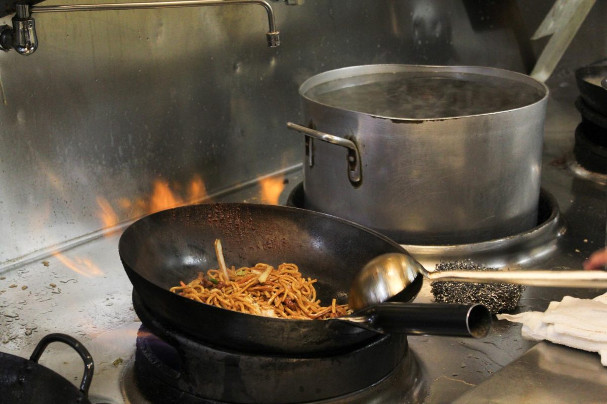 Kitchen staff tosses up broccoli beef in a wok as flames shoot out at Chopstix on E. Green Street, Feb. 18.