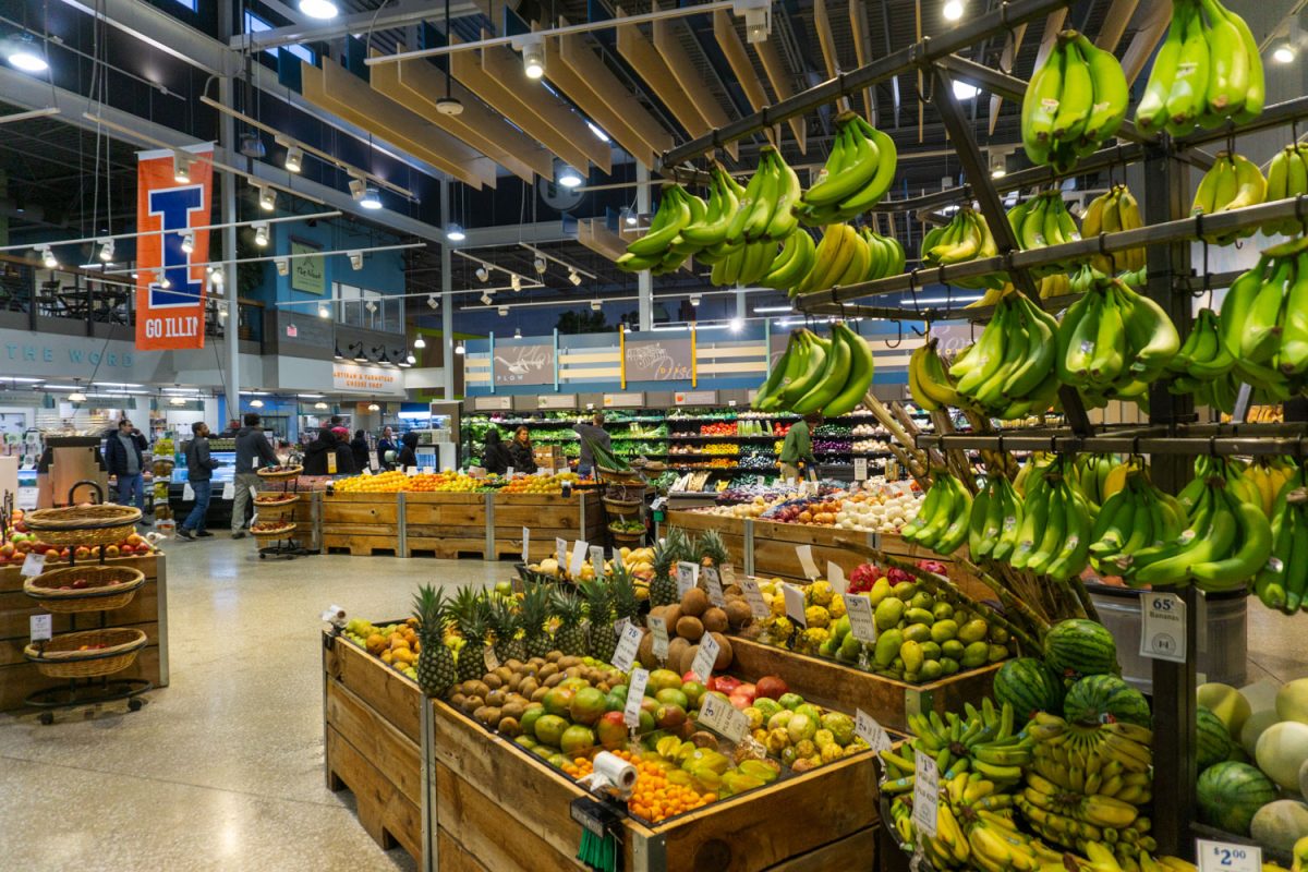 Fruits lay in crates hang on racks for shoppers to add to their cart at Harvest Market on Feb. 18.