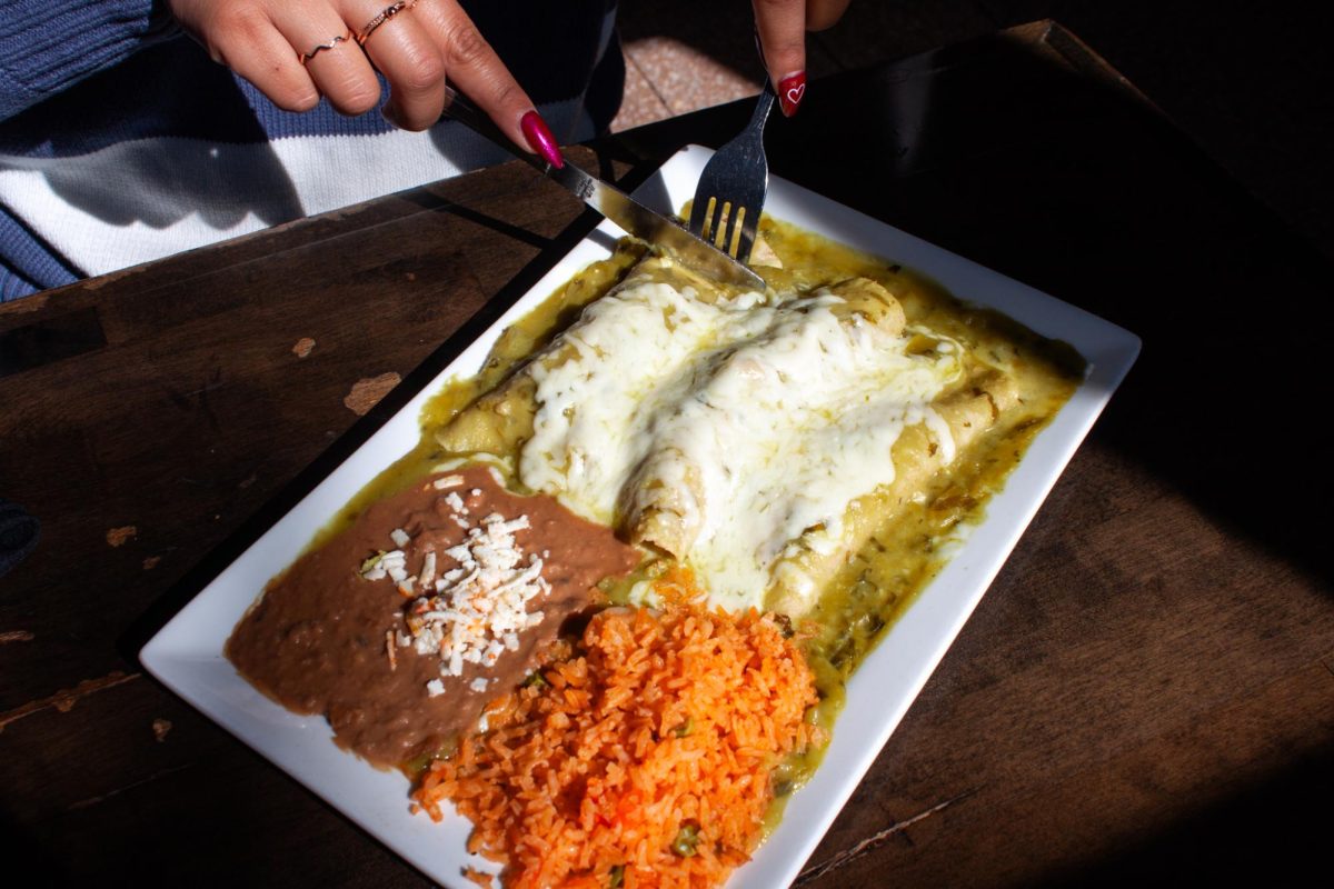 A customer cuts through chicken enchilada onto her fork at Maize Mexican Grill on Feb. 25.