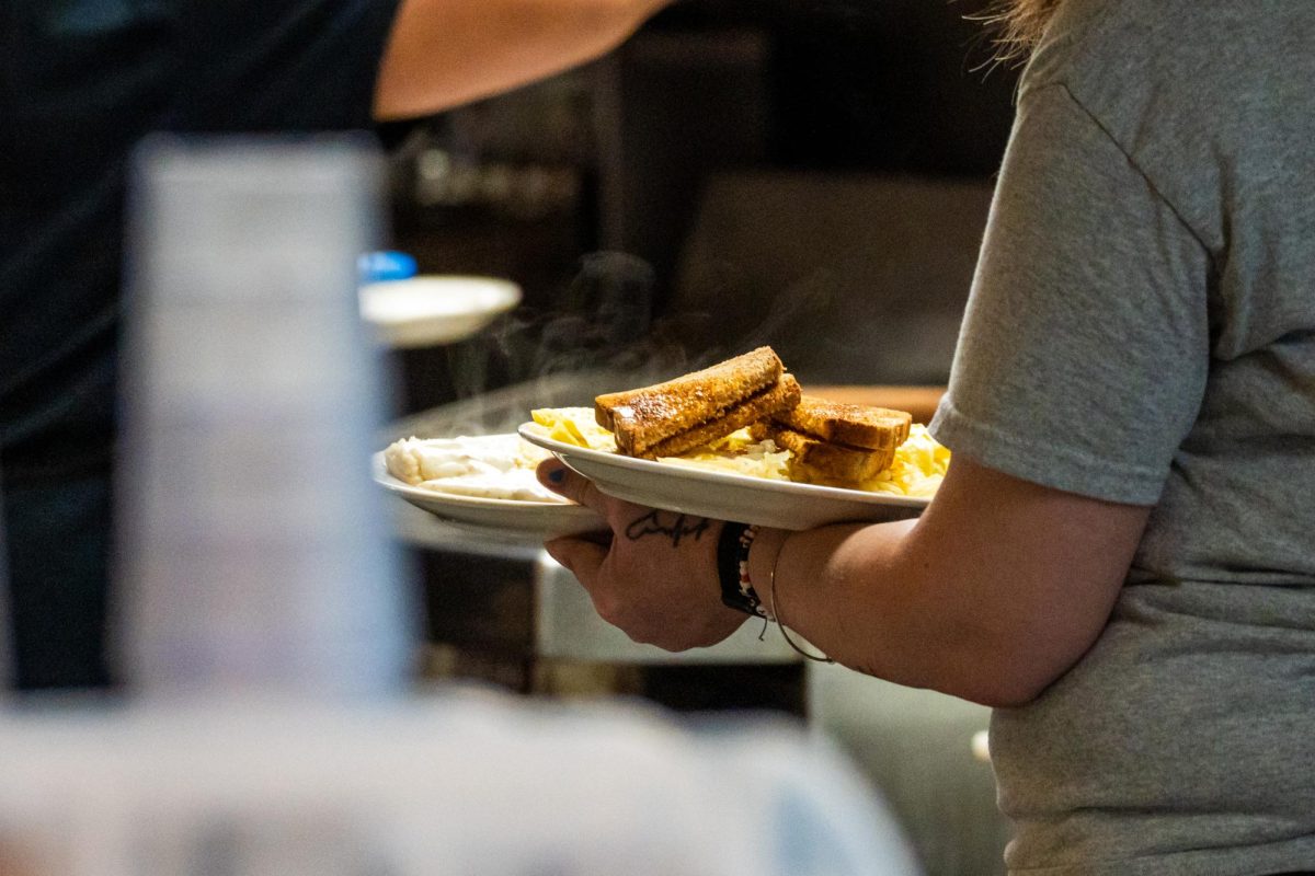 A waitress brings out plates of smoking hot toast, eggs, biscuits and gravy to a table in Merry-Ann's Diner on the corner of W Kirby Ave. and S Neil St. on Feb 28.
