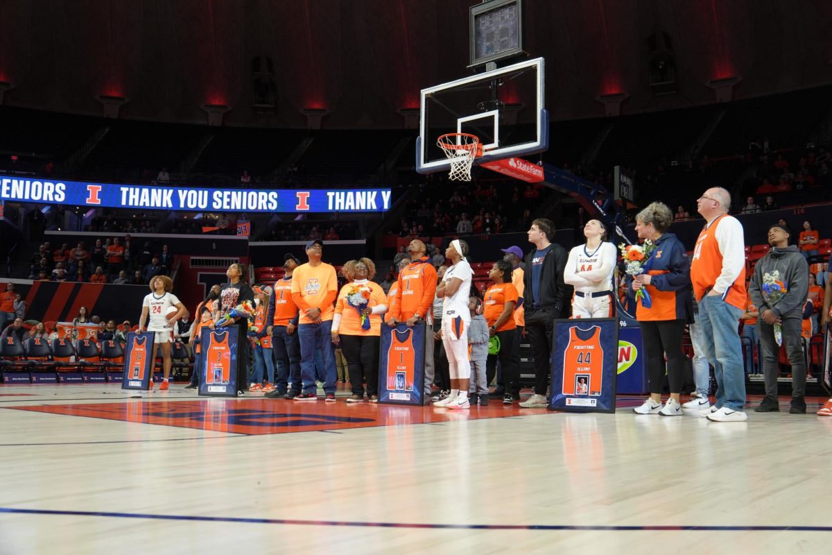 Illinois seniors and their families glance at the Jumbotron for their Senior Day ceremony on March 2.  