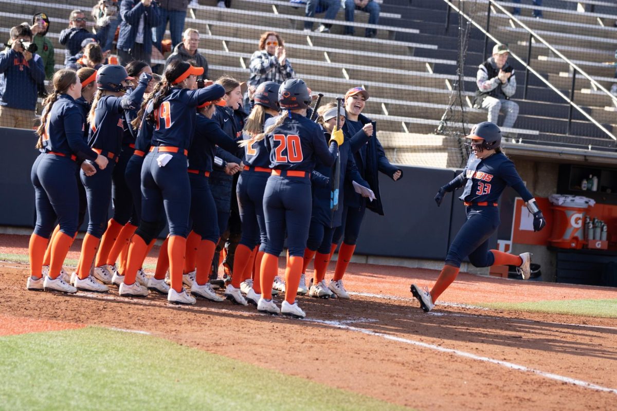 The Illini celebrate at home plate as redshirt sophomore utility player Yazzy Avila rounds her way around the diamond after a home run on March 3.
