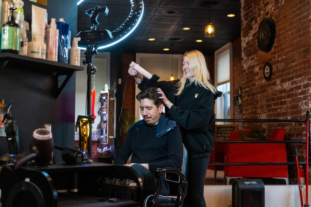 Cheyenne Clark, a barber at The Den Hair Emporium, blow-dries a customer after a haircut on Mar. 4.