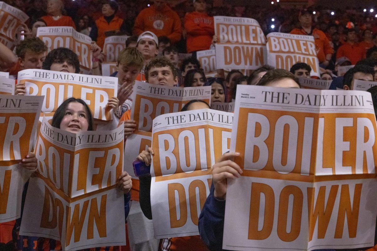 The Orange Krush student section waves their Daily Illini newspapers during pregame introductions against Purdue on March 5, 2024. 