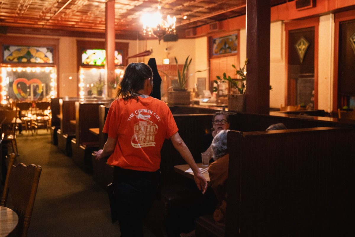 A staff server at Courier Cafe apporaches a table of customers on Feb. 28.