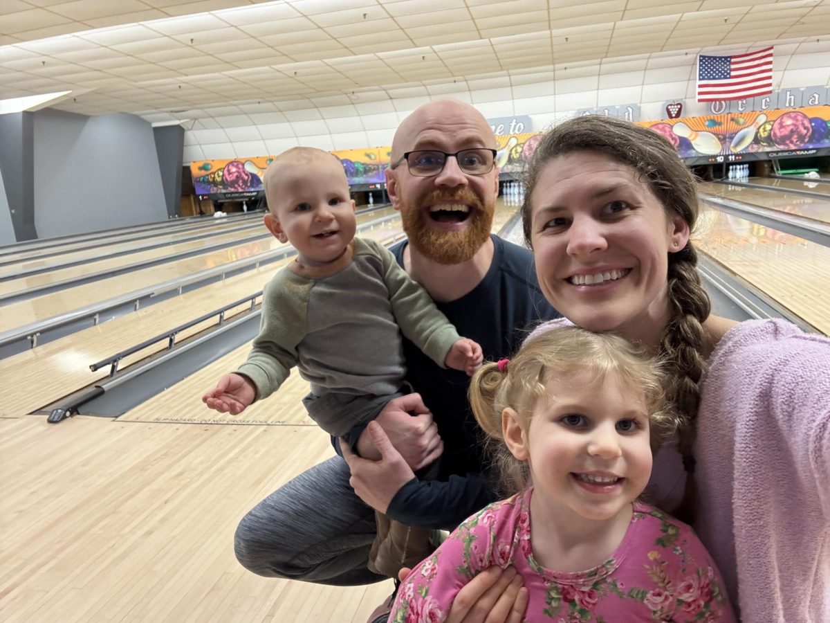 Justin Holmes, a graduate student studying sociology, and his family at a bowling alley. Holmes says his family was financially and emotionally affected after the University increased health insurance costs.