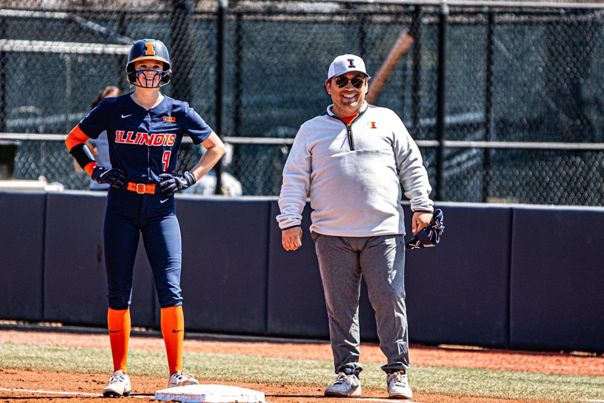 (L-R) Redshirt sophomore outfielder Alaina Miller and assistant coach Brendan Goler look towards the mound from first base during the game against Michigan State on April 12. 