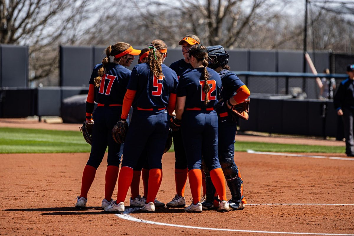 The Illini huddle near the pitching circle during their game against the Michigan State Spartans on April 16.
