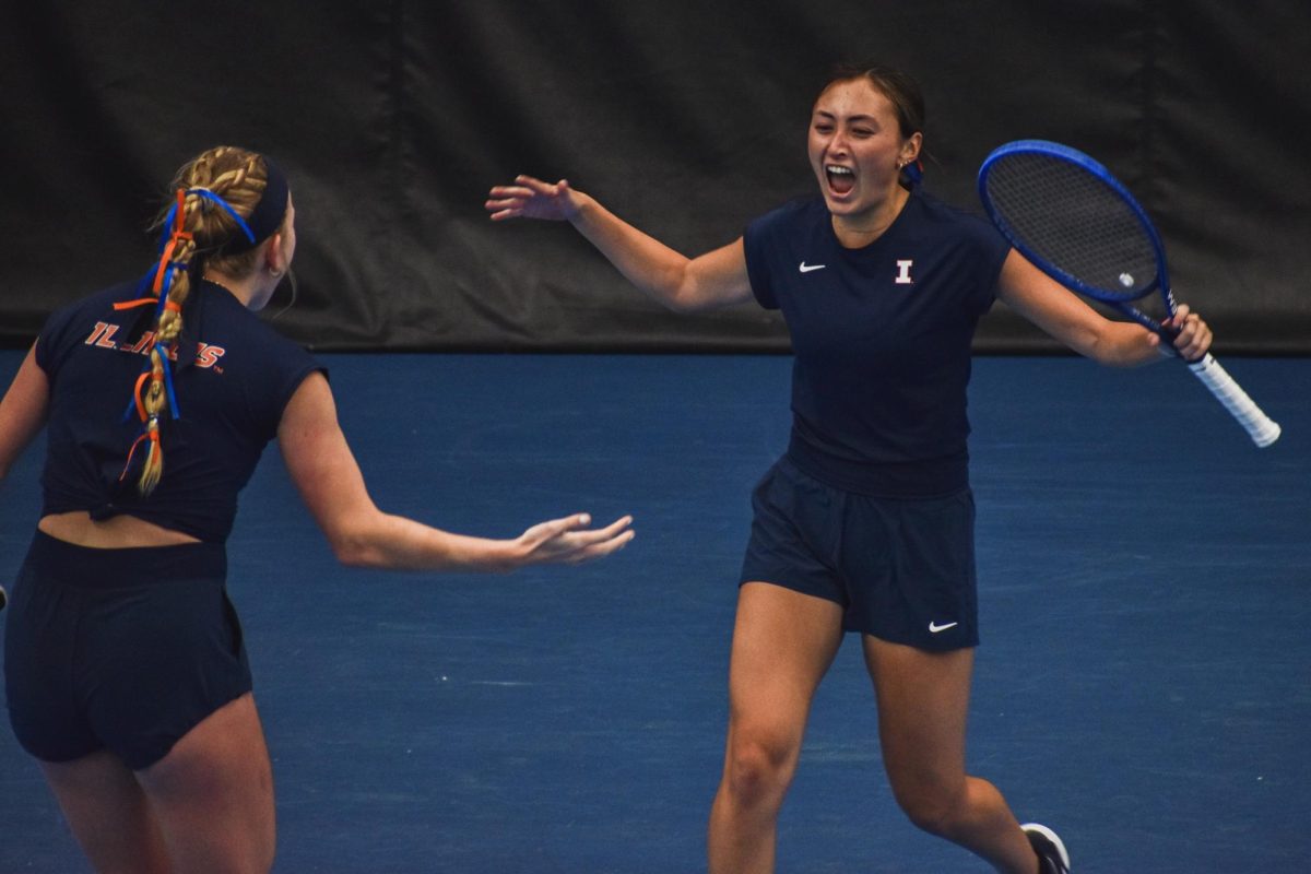 (L-R) Seniors Megan Heuser and Kida Ferrari celebrate at a match against Northwestern on Jan. 25. 