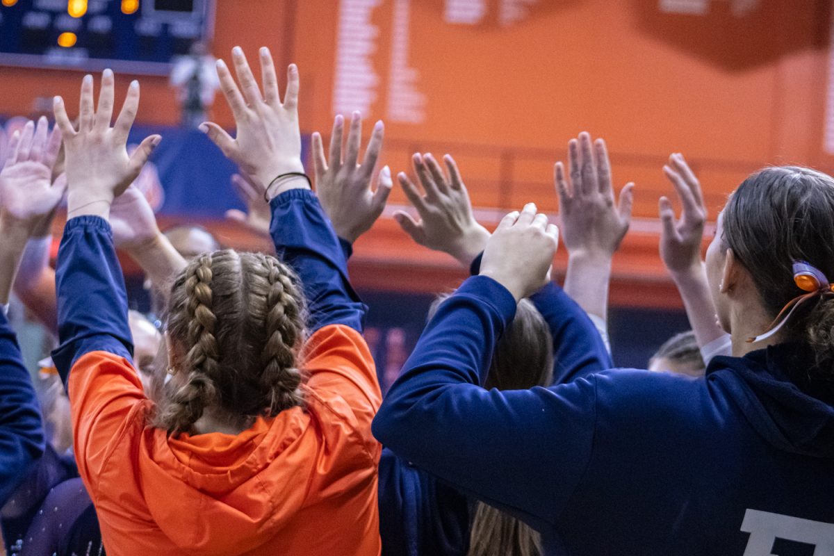 Members of the women's gymnastics team raise their hands to high-five a teammate during a meet against Ohio State on Mar. 7. 