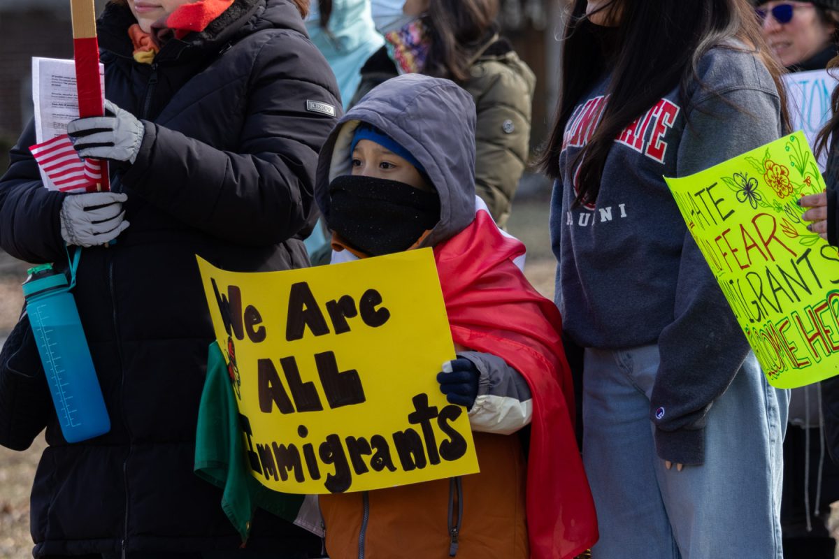 A young protester holds a sign that reads, “We Are ALL Immigrants” at a protest against the Trump administration at West Side Park on March 1.