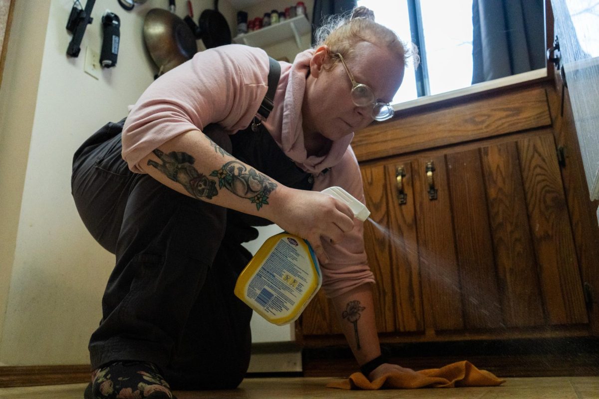 Iris Graves, a cleaner based in Urbana, gets on her hands and knees to mop the kitchen floor of one of her clients on April 3.
