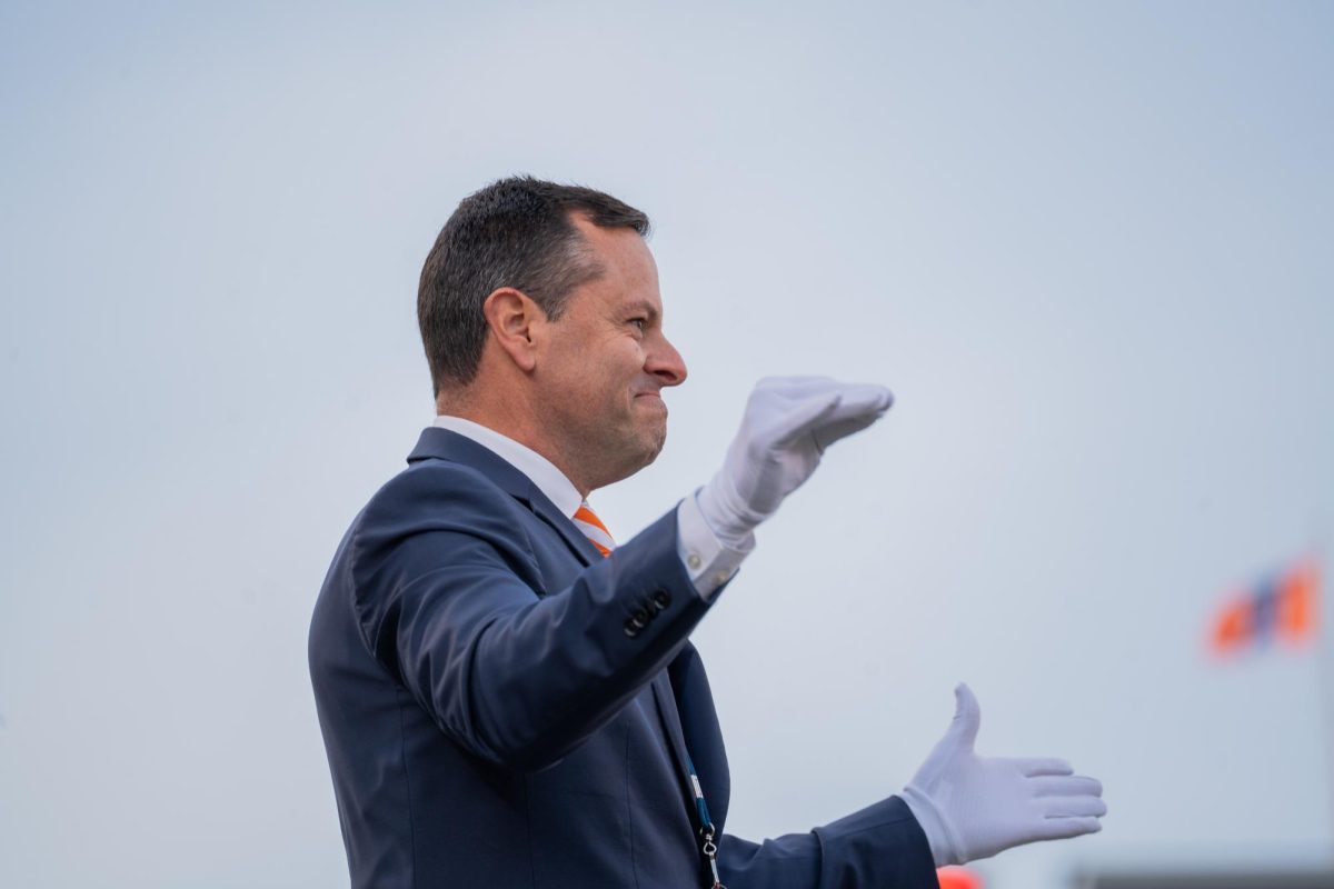 Director of the Marching Illini Barry L. Houser looks proudly upon his band during the halftime show of the last home game of the season against Michigan State on Nov. 16.