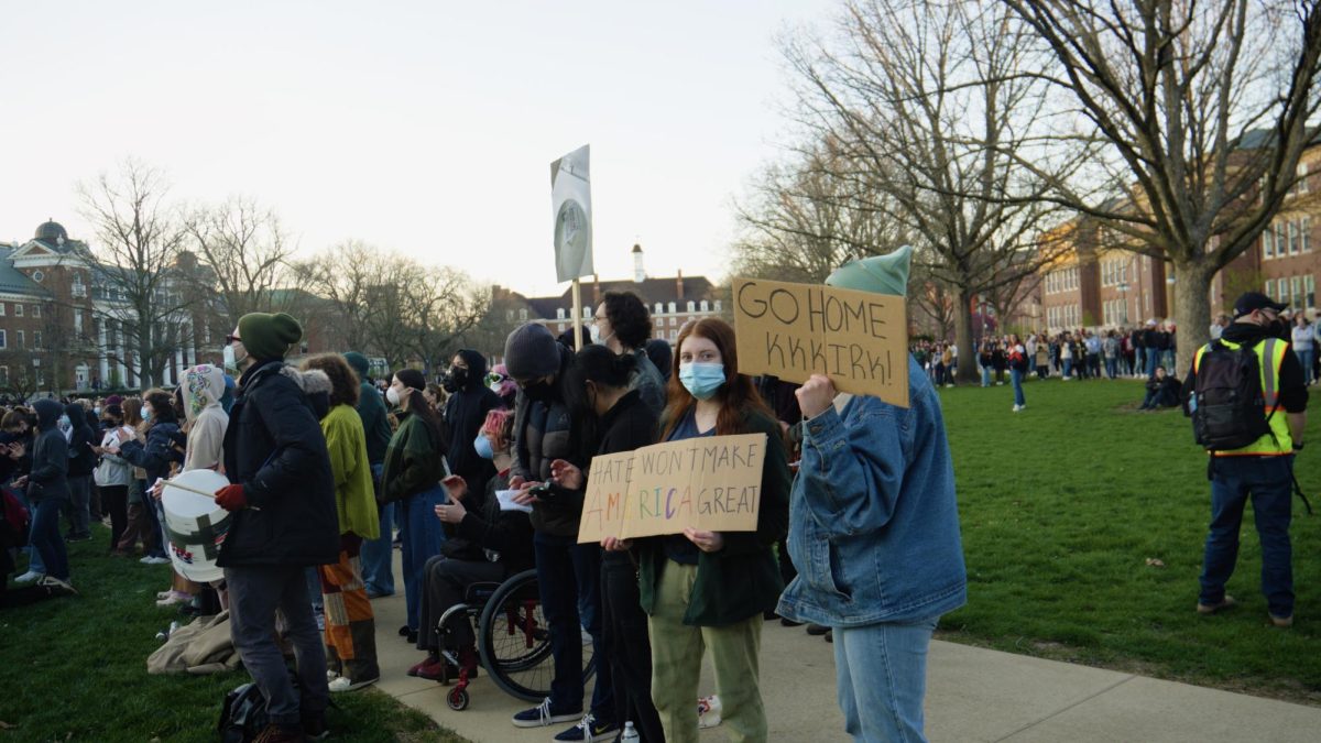 Protestors hold signs opposing Kirk before his scheduled appearance at Foellinger Auditorium on Tuesday. 