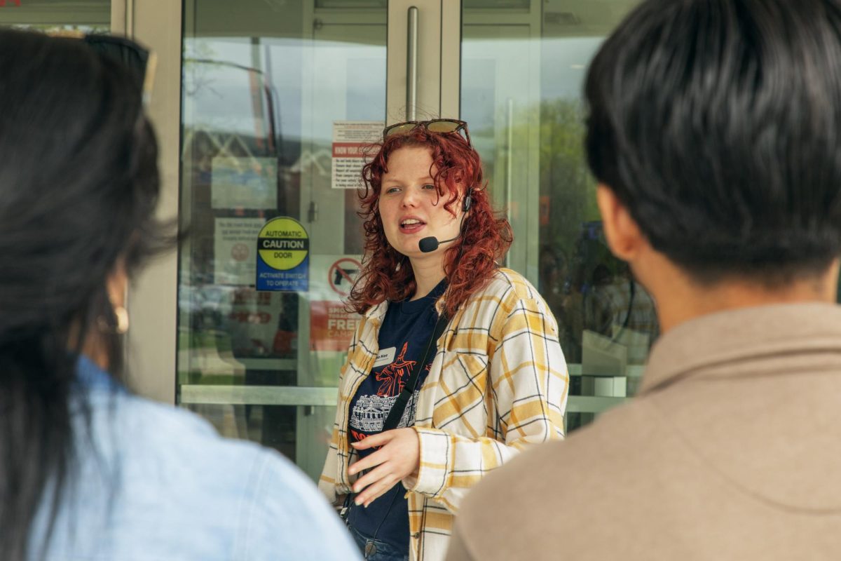 Brianna Mae Huner, senior staff member and junior in LAS, explains dorm and dining hall options to her tour group outside of ISR on April 25.